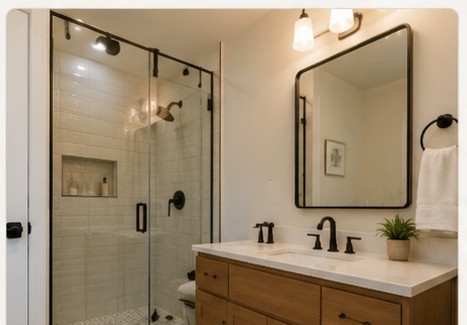 Remodeled bathroom with glass shower and wood vanity